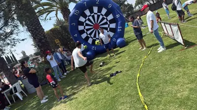 Familias disfrutando juntas de juegos inflables de Pelotinas en un evento al aire libre.